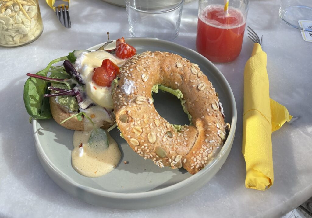 Frankfurt food—a breakfast bagel at Sunny Side Up containing eggs, cheese, tomatoes, avocado and salad